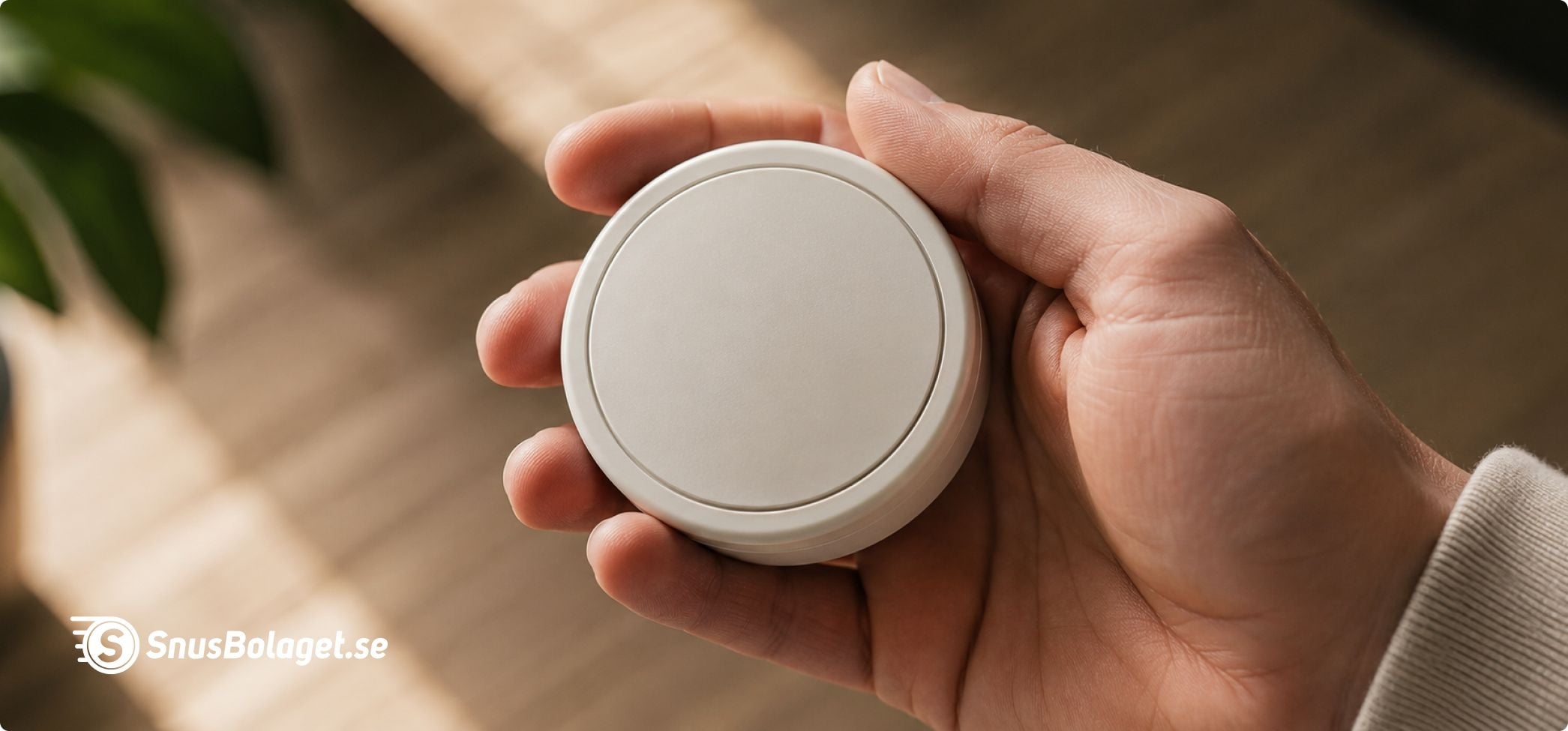En stängd snusdosa i en hand